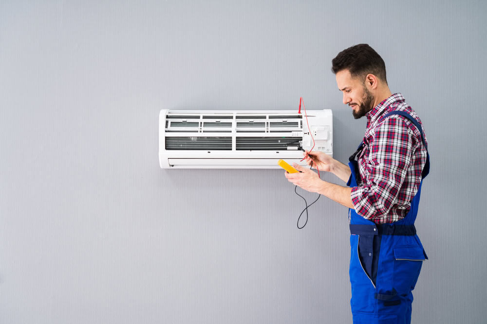 Technician servicing a wall mounted air conditioner